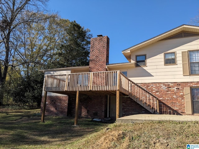 back of property with a yard and a deck