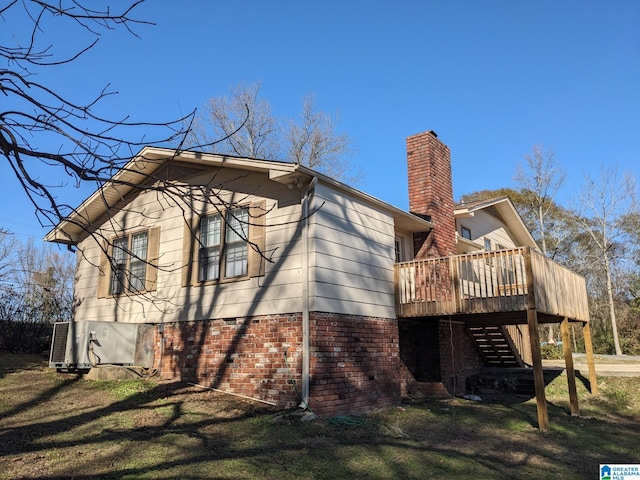 rear view of property with a lawn and a deck