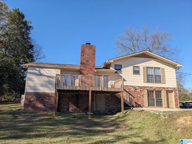 back of house featuring a lawn and a wooden deck