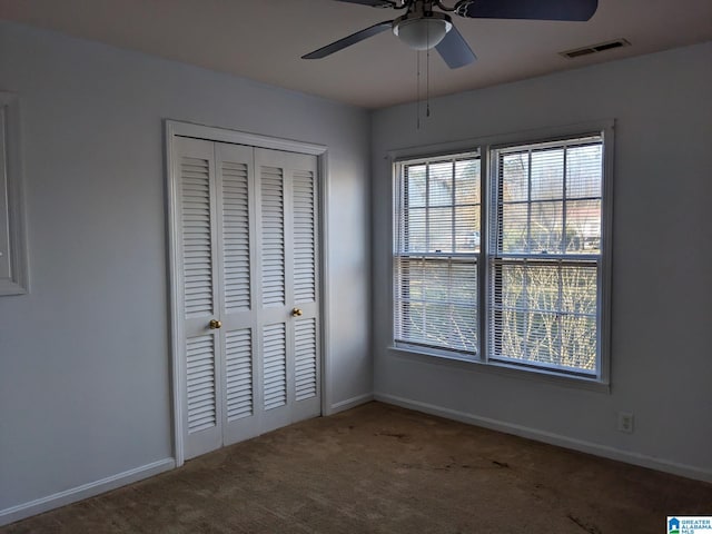 unfurnished bedroom featuring carpet flooring, ceiling fan, and a closet