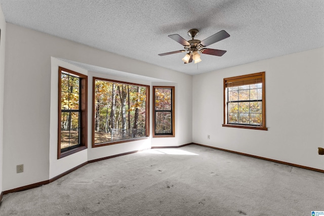 carpeted spare room with ceiling fan and a textured ceiling