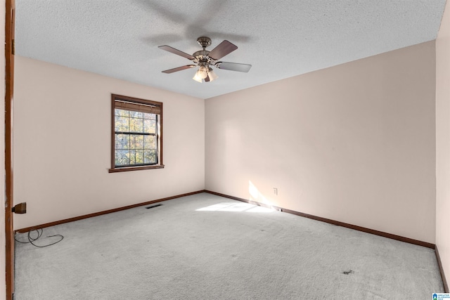 carpeted spare room with a textured ceiling and ceiling fan