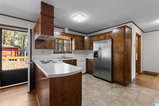 kitchen featuring stainless steel fridge, dishwasher, a textured ceiling, and light hardwood / wood-style flooring