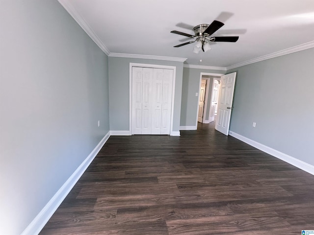 unfurnished bedroom with ornamental molding, a closet, ceiling fan, and dark wood-type flooring