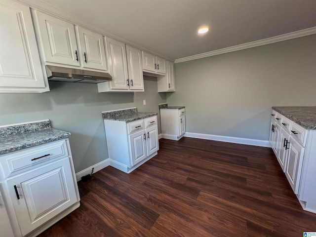 kitchen featuring dark stone counters, dark wood-type flooring, white cabinetry, and ornamental molding