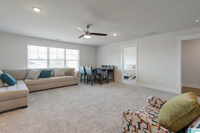 carpeted living room with ceiling fan