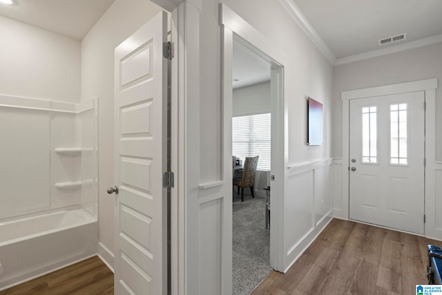 foyer entrance with crown molding, plenty of natural light, and hardwood / wood-style flooring