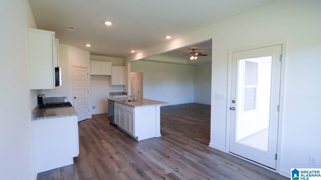 kitchen featuring a center island with sink, white cabinetry, dark wood-type flooring, and sink