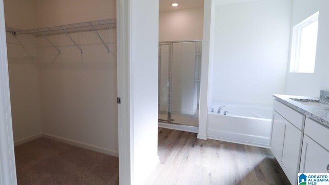 bathroom with shower with separate bathtub, vanity, and wood-type flooring