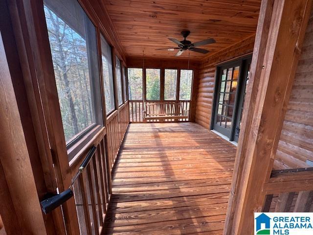 unfurnished sunroom featuring ceiling fan and wood ceiling