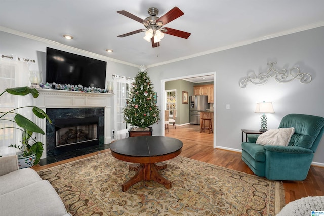 living room featuring a fireplace, crown molding, and hardwood / wood-style floors