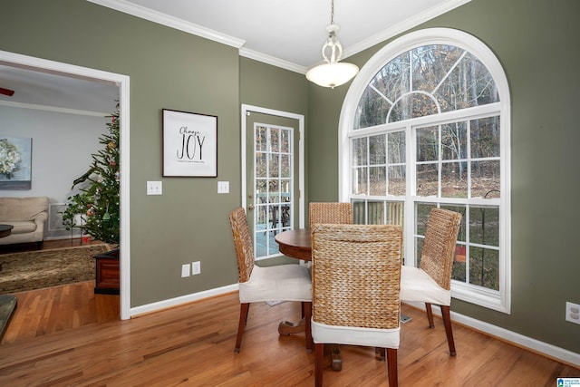 dining area with hardwood / wood-style flooring, plenty of natural light, and crown molding