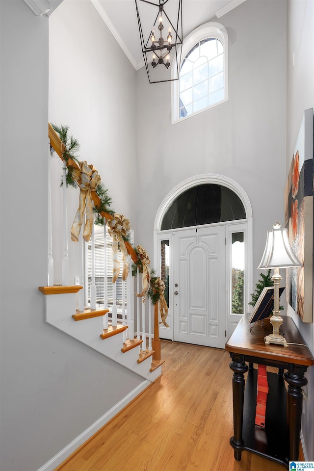 foyer entrance featuring plenty of natural light, crown molding, and light hardwood / wood-style flooring