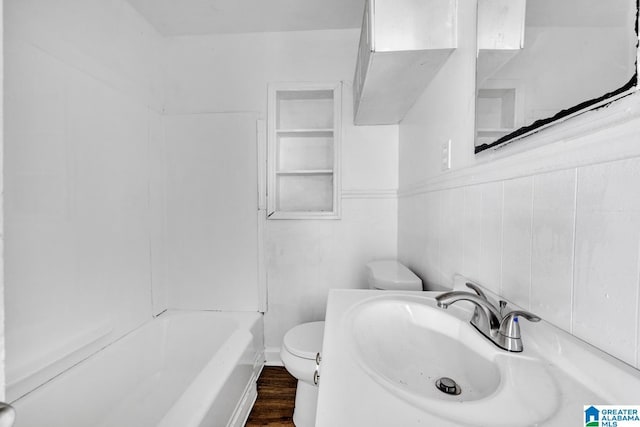 bathroom featuring hardwood / wood-style floors, toilet, sink, and tile walls