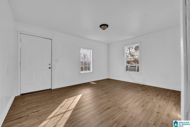 interior space with hardwood / wood-style flooring and cooling unit