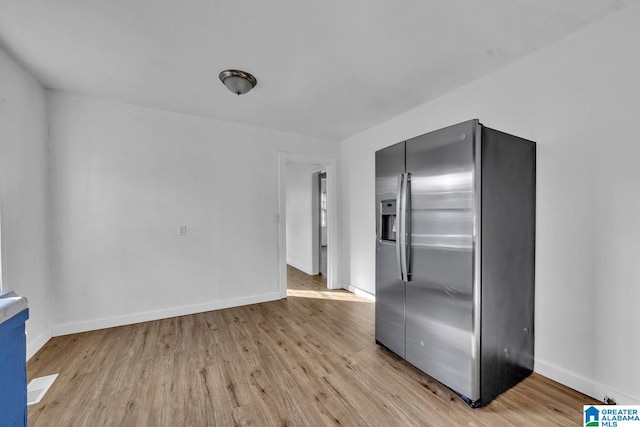 kitchen with stainless steel fridge and light hardwood / wood-style floors