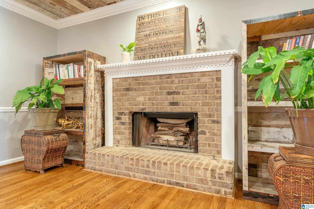 living area with wooden ceiling, wood-type flooring, ornamental molding, and a brick fireplace