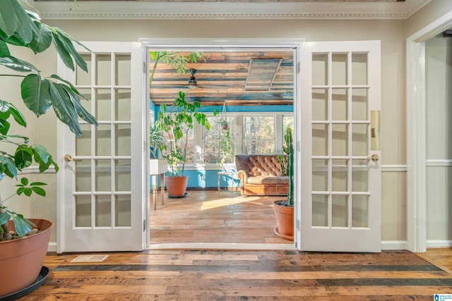 doorway to outside featuring hardwood / wood-style flooring, ornamental molding, and french doors