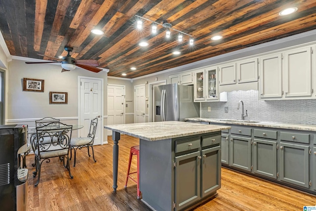 kitchen featuring a center island, stainless steel fridge with ice dispenser, sink, and light hardwood / wood-style flooring