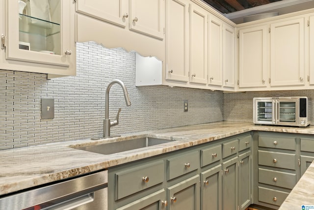 kitchen with light stone countertops, tasteful backsplash, sink, dishwasher, and white cabinetry