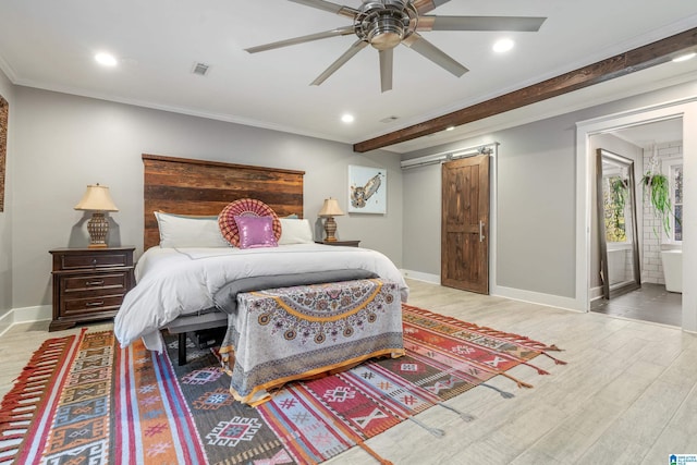 bedroom with ceiling fan, light hardwood / wood-style floors, a barn door, and ornamental molding