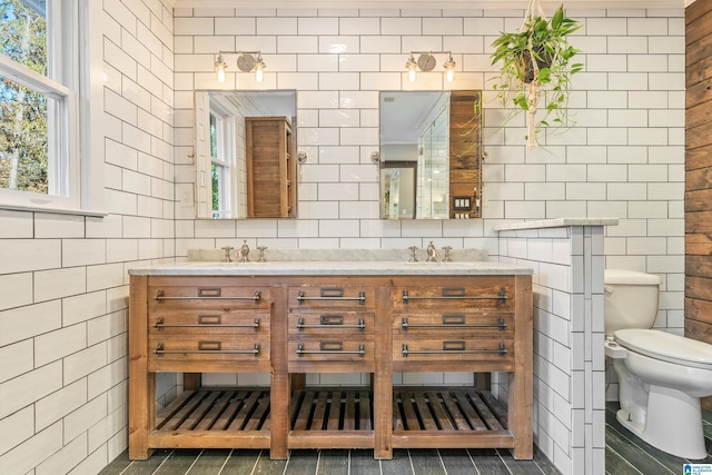 bathroom featuring vanity, toilet, and tile walls