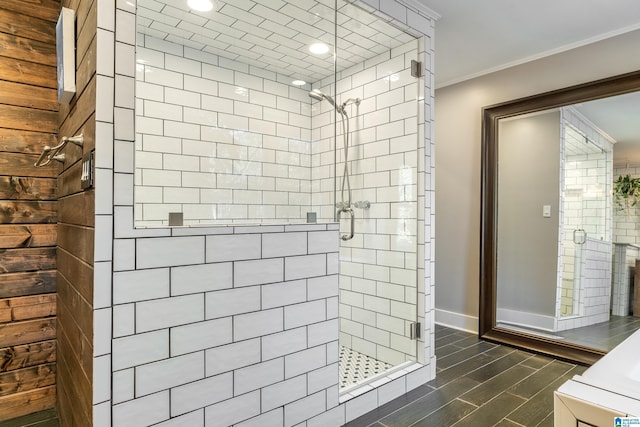 bathroom with a shower with shower door and crown molding