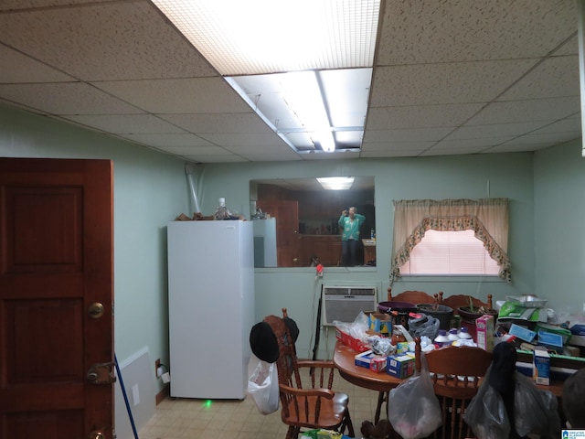 dining area featuring a paneled ceiling and a wall unit AC