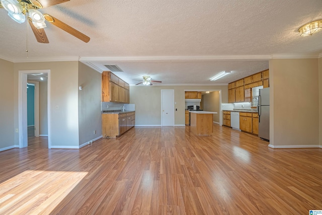 unfurnished living room featuring ceiling fan, light hardwood / wood-style flooring, a textured ceiling, and ornamental molding