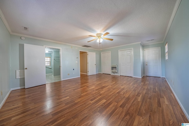 unfurnished bedroom featuring multiple closets, ceiling fan, dark hardwood / wood-style flooring, crown molding, and a textured ceiling