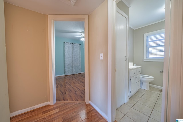 hallway featuring ornamental molding and light wood-type flooring