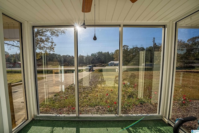 unfurnished sunroom with ceiling fan