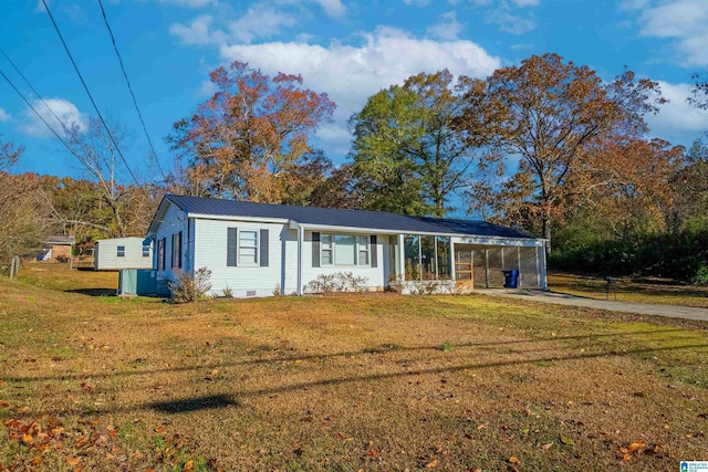 single story home with a front yard, a carport, and a sunroom