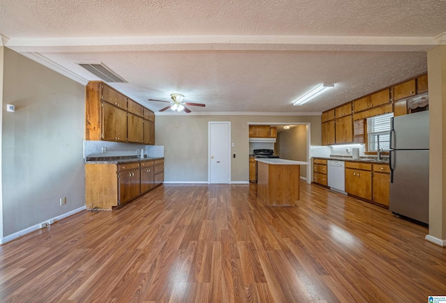 kitchen featuring dishwasher, crown molding, stainless steel fridge, a textured ceiling, and wood-type flooring