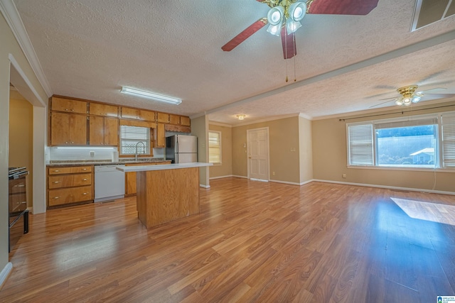 kitchen featuring stainless steel refrigerator, dishwasher, a textured ceiling, and light hardwood / wood-style flooring