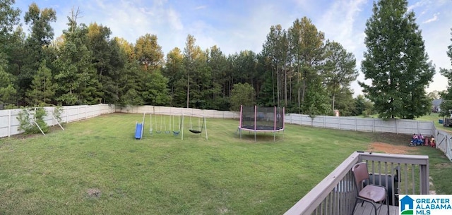 view of yard with a playground and a trampoline