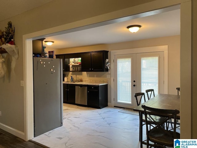 kitchen with appliances with stainless steel finishes, french doors, and sink