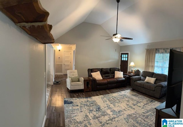 living room with ceiling fan, dark hardwood / wood-style flooring, and vaulted ceiling