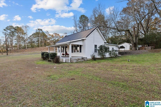 view of side of home featuring a porch and a yard