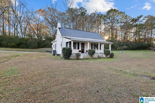 view of front of home featuring a front lawn, cooling unit, and a porch