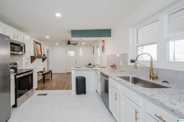 7321 Naples Ave, Birmingham, AL 35206 - kitchen featuring appliances with stainless steel finishes, a sink, a ceiling fan, decorative backsplash, and recessed lighting