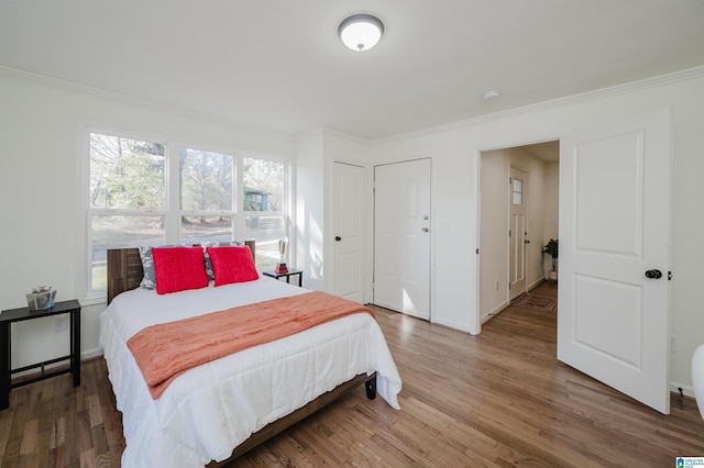 bedroom featuring ornamental molding and dark wood-type flooring