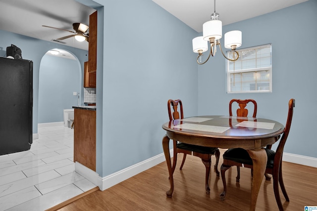 dining room with ceiling fan with notable chandelier and light wood-type flooring