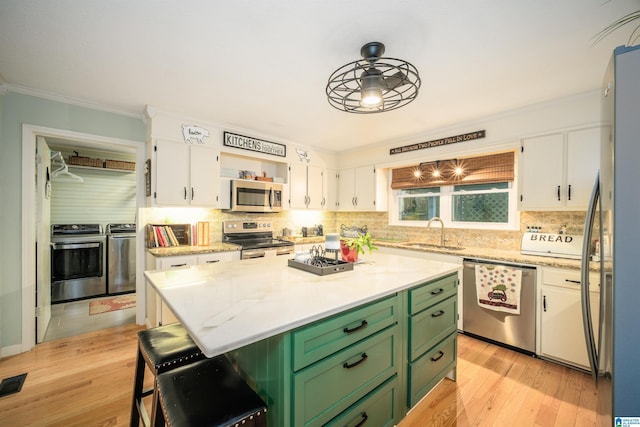 kitchen featuring sink, light hardwood / wood-style flooring, appliances with stainless steel finishes, white cabinets, and green cabinetry