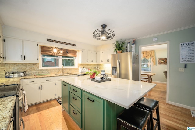 kitchen with white cabinetry, sink, green cabinets, a kitchen island, and appliances with stainless steel finishes