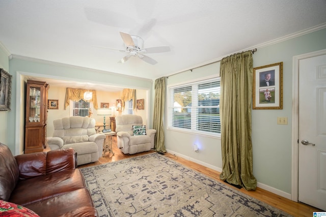 living room featuring hardwood / wood-style floors, ceiling fan, and ornamental molding