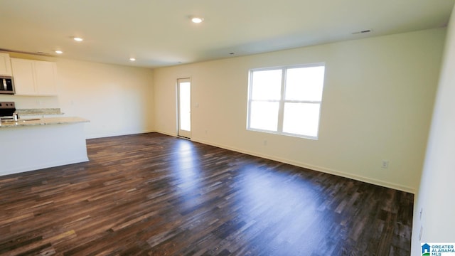 unfurnished living room featuring dark wood-type flooring and sink