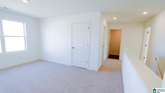 unfurnished room featuring light carpet