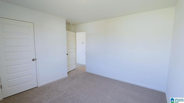 unfurnished bedroom with light carpet and a closet