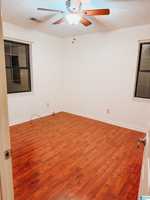 empty room with wood-type flooring, a textured ceiling, and ceiling fan